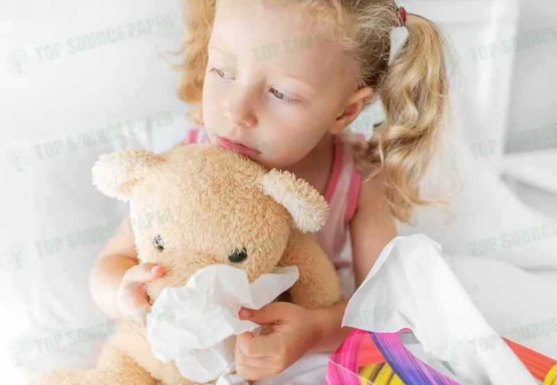 A child gently cleans the nose of a playful teddy bear.