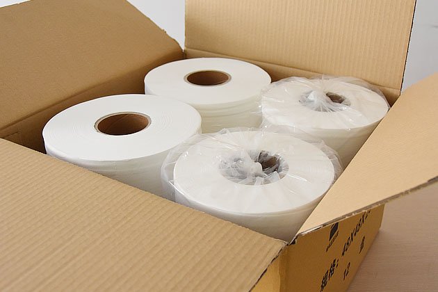 Four jumbo toilet tissue rolls packed in an export carton, two shrink-wrapped