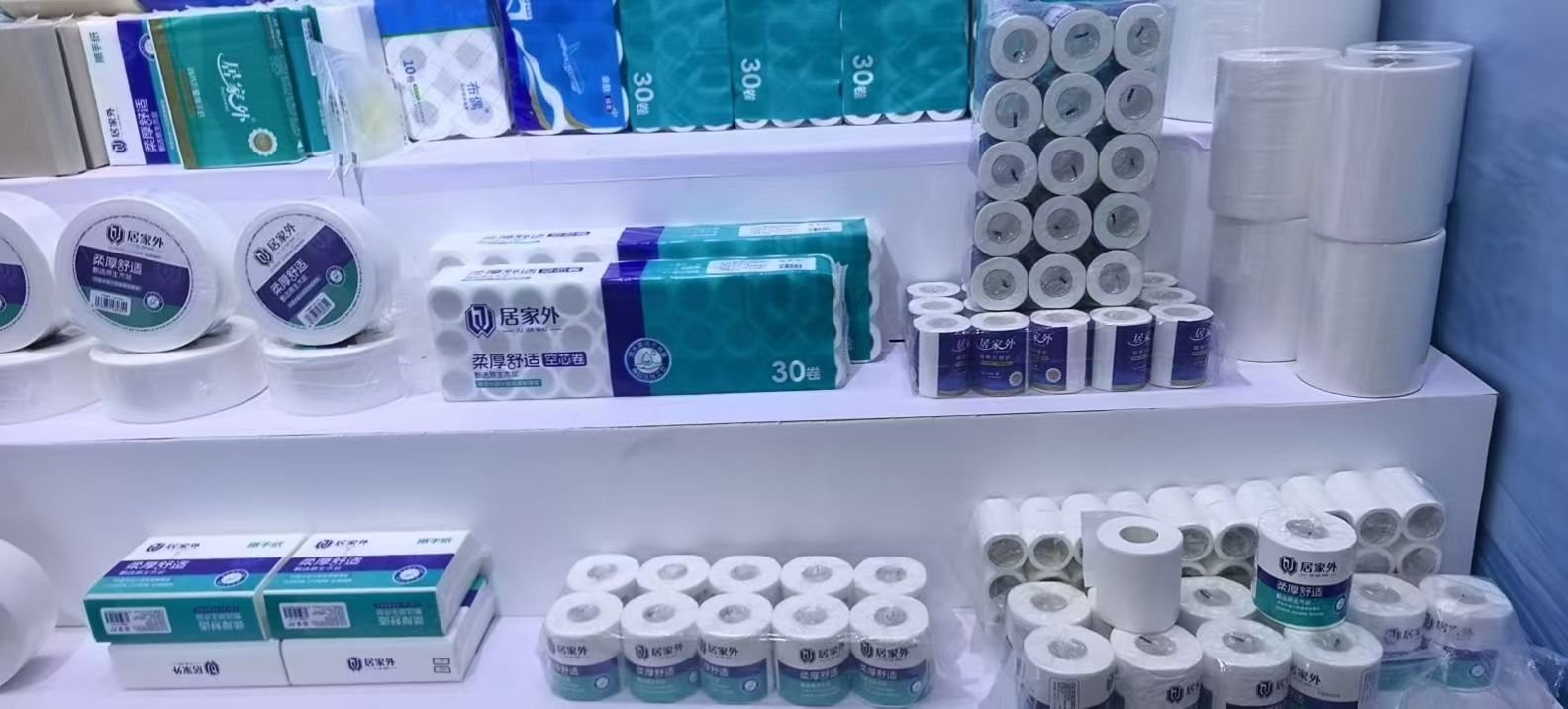 Assorted toilet paper rolls and packaged multi-packs on a showroom display shelf
