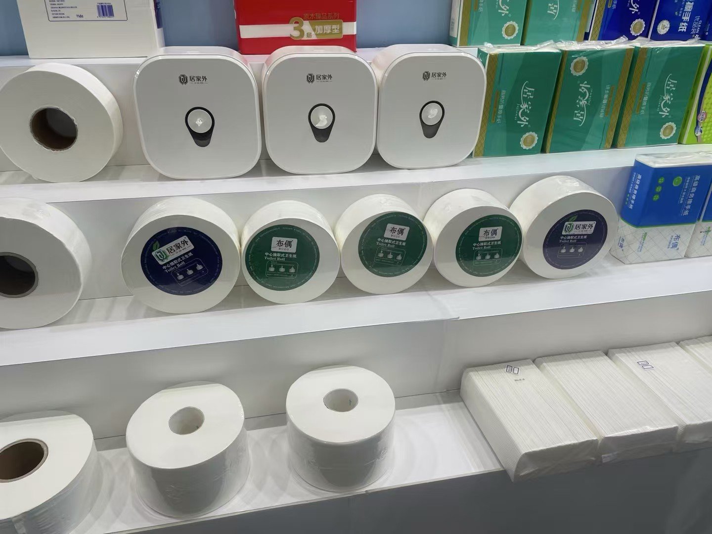 Center-pull jumbo toilet rolls with printed label faces on a display shelf