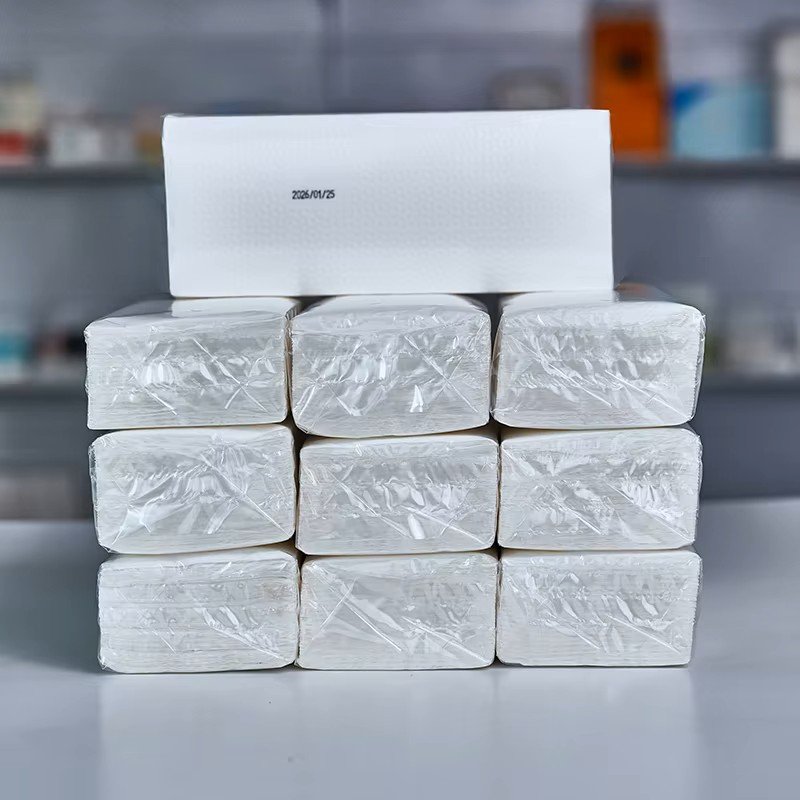 Shrink-wrapped blocks of folded hand towels stacked three by three with a date-coded pack on top