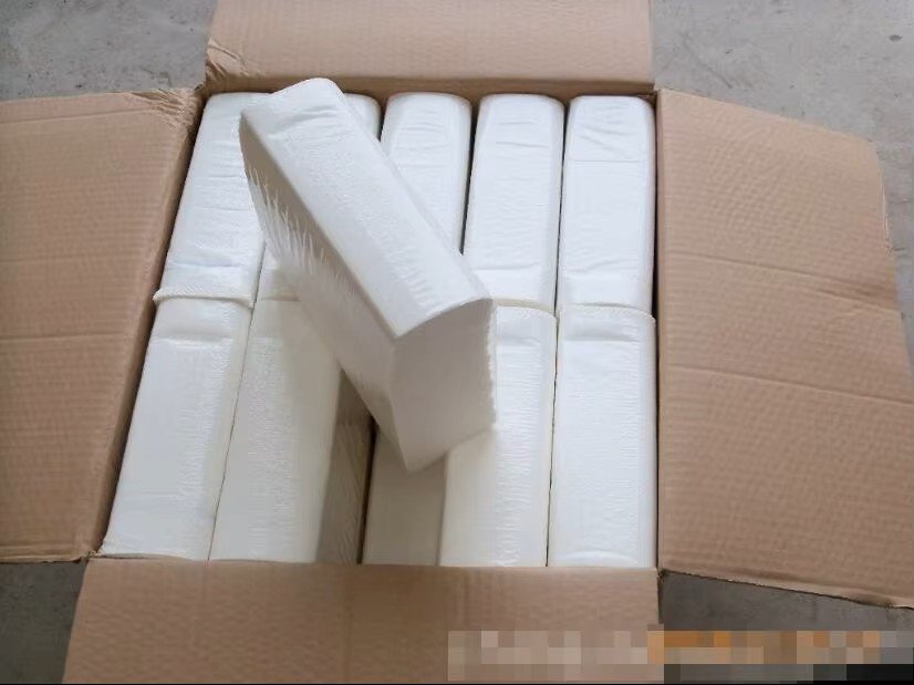 Open corrugated master carton with shrink-wrapped hand towel packs nested flat and one pack set on top